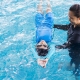 Woman teaching boy how to swim